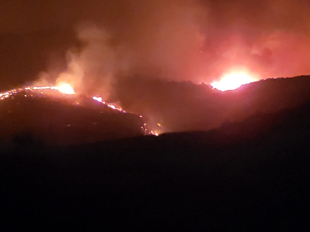Wildfire glowing on the hills at night