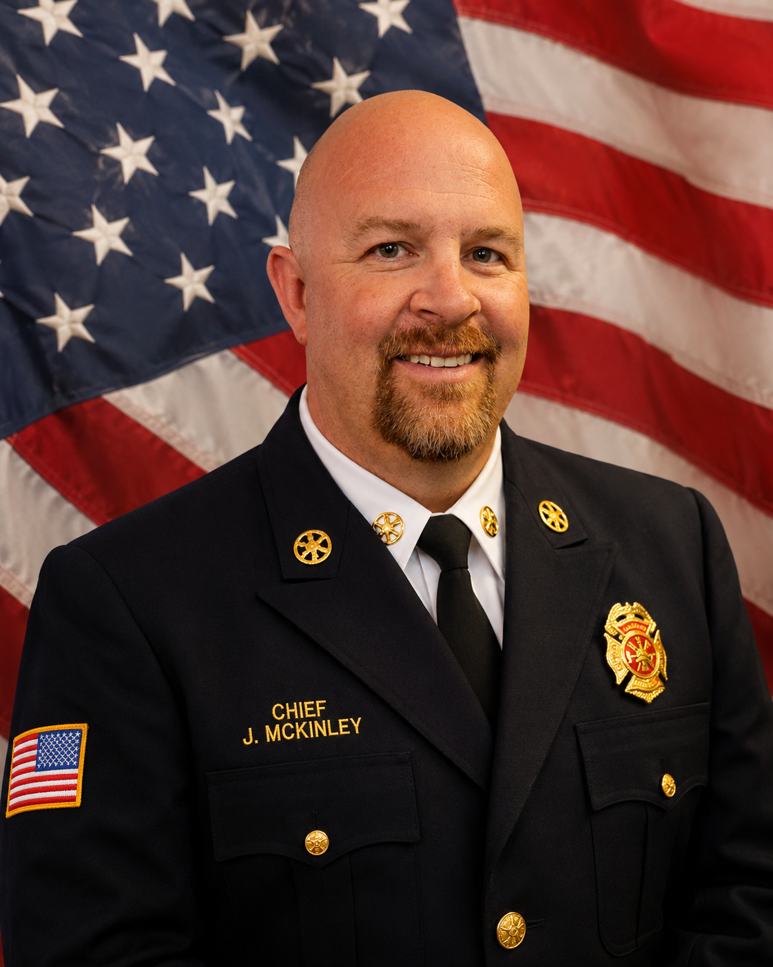 Fire Chief Josh McKinley in dress uniform in front of an American flag